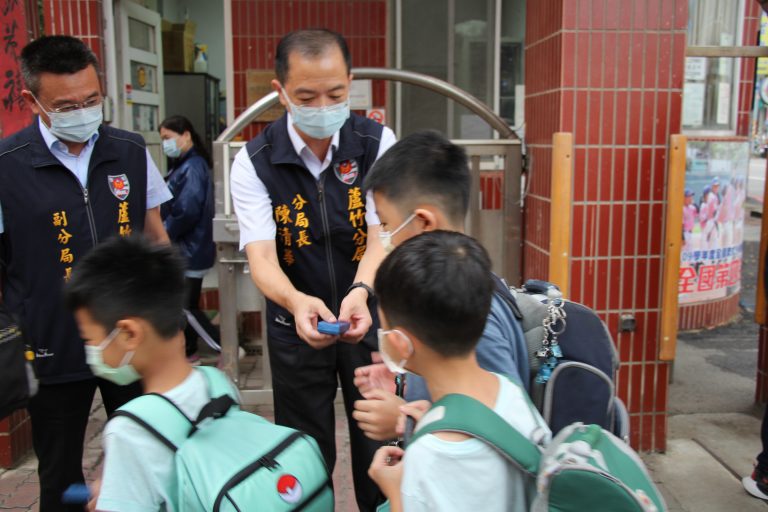 圖片說明：蘆竹分局長陳清華（右）與副分局長高海源（左）在校門前迎接學童。(記者宋紹誠翻攝)