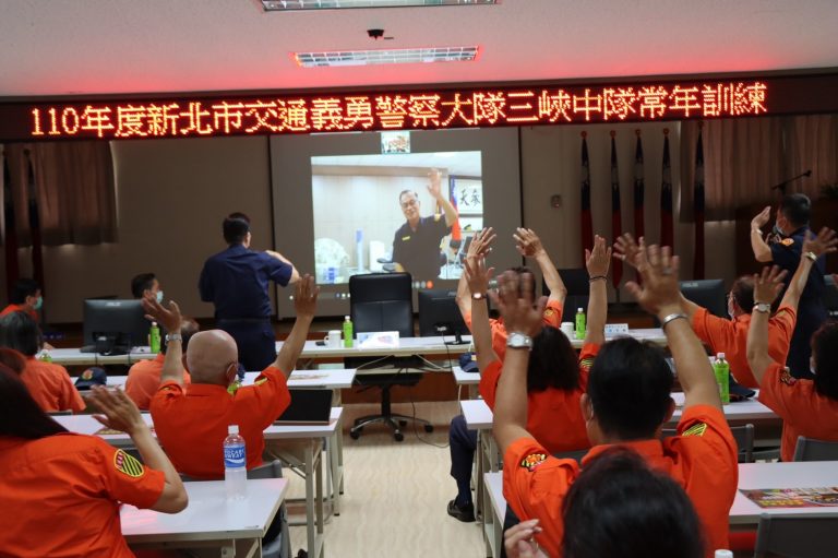 圖片說明：阿仁局長非常重視民力，因需前往議會，但又心繫三峽中隊義交人員訓練情形，首創用視訊連線與現場的義交人員互動。(記者宋紹誠翻攝)