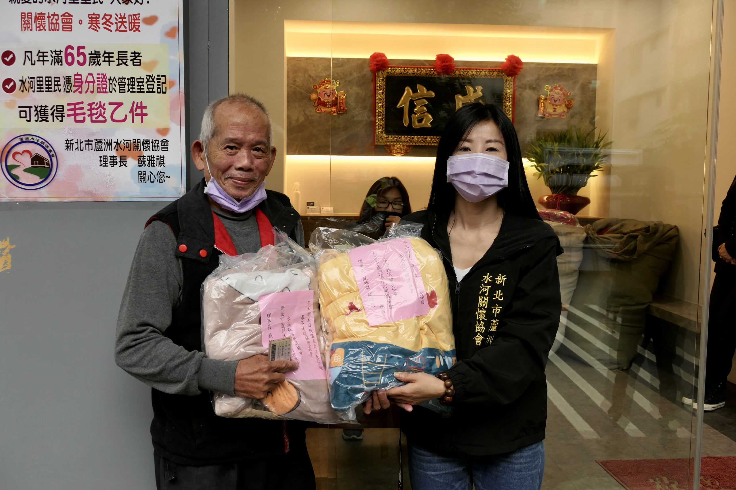圖片說明：當地居民從蘇理事長（右）手中領到毛毯。(記者朱珈瑩攝)