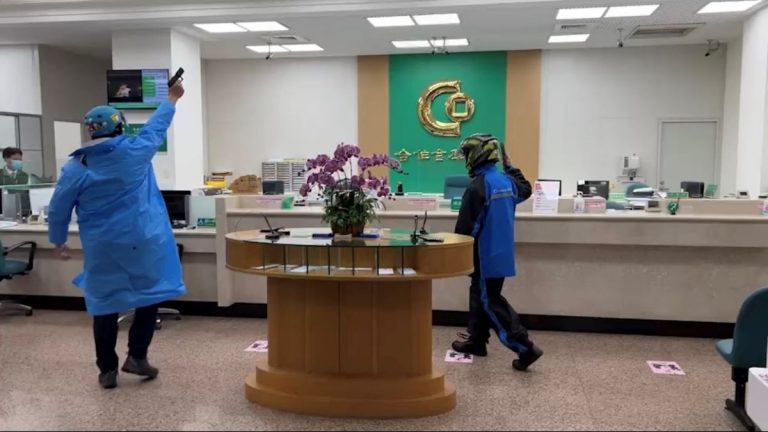 圖片說明：內湖分局員警飾演持槍搶匪打劫銀行。(記者徐歆媛翻攝)