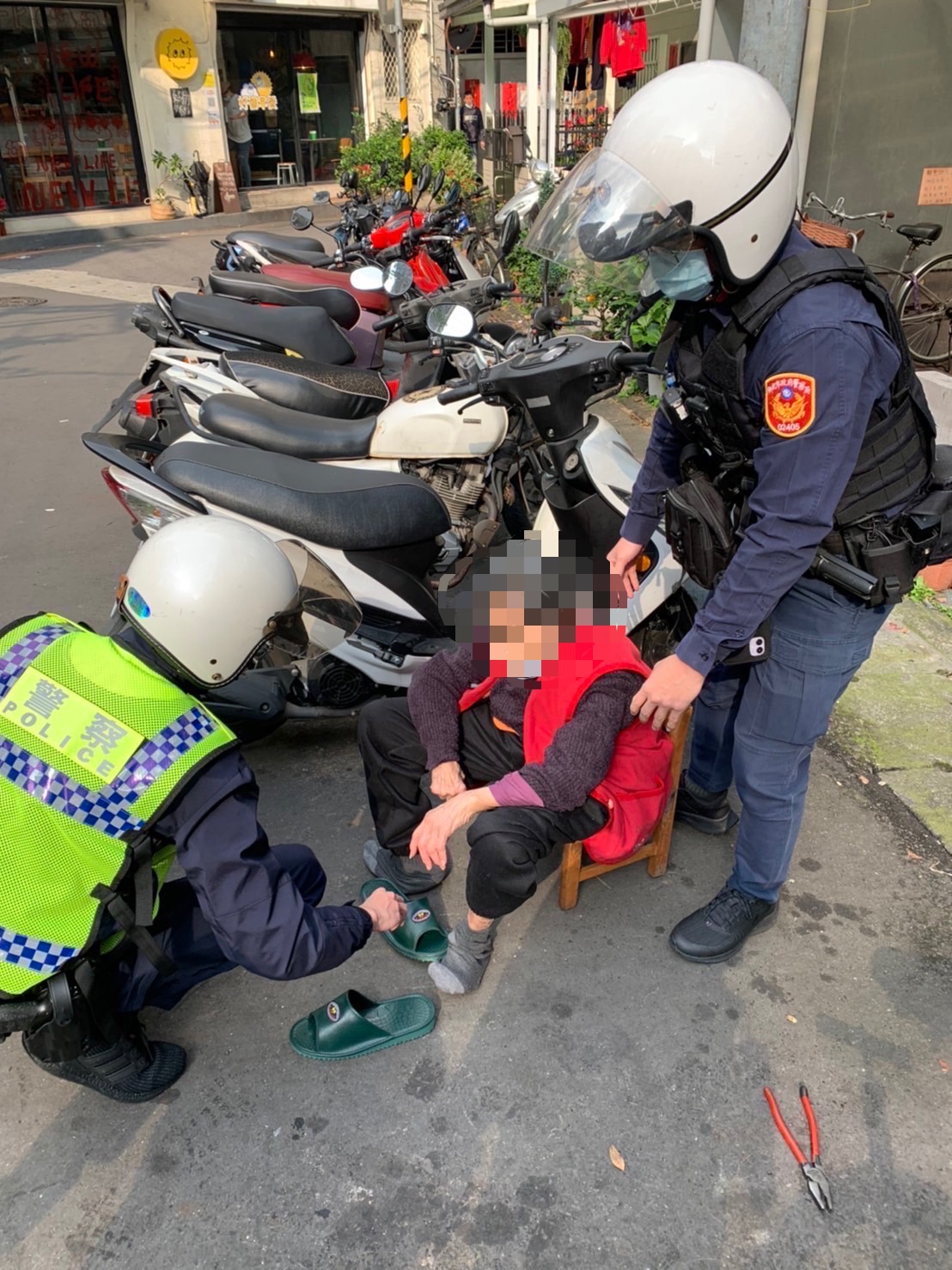 圖片說明：江翠派出所警員李祁彥、蔡宗儒、王宏瑋合力將老奶奶攙扶背返住家。(記者林鈞澤翻攝)