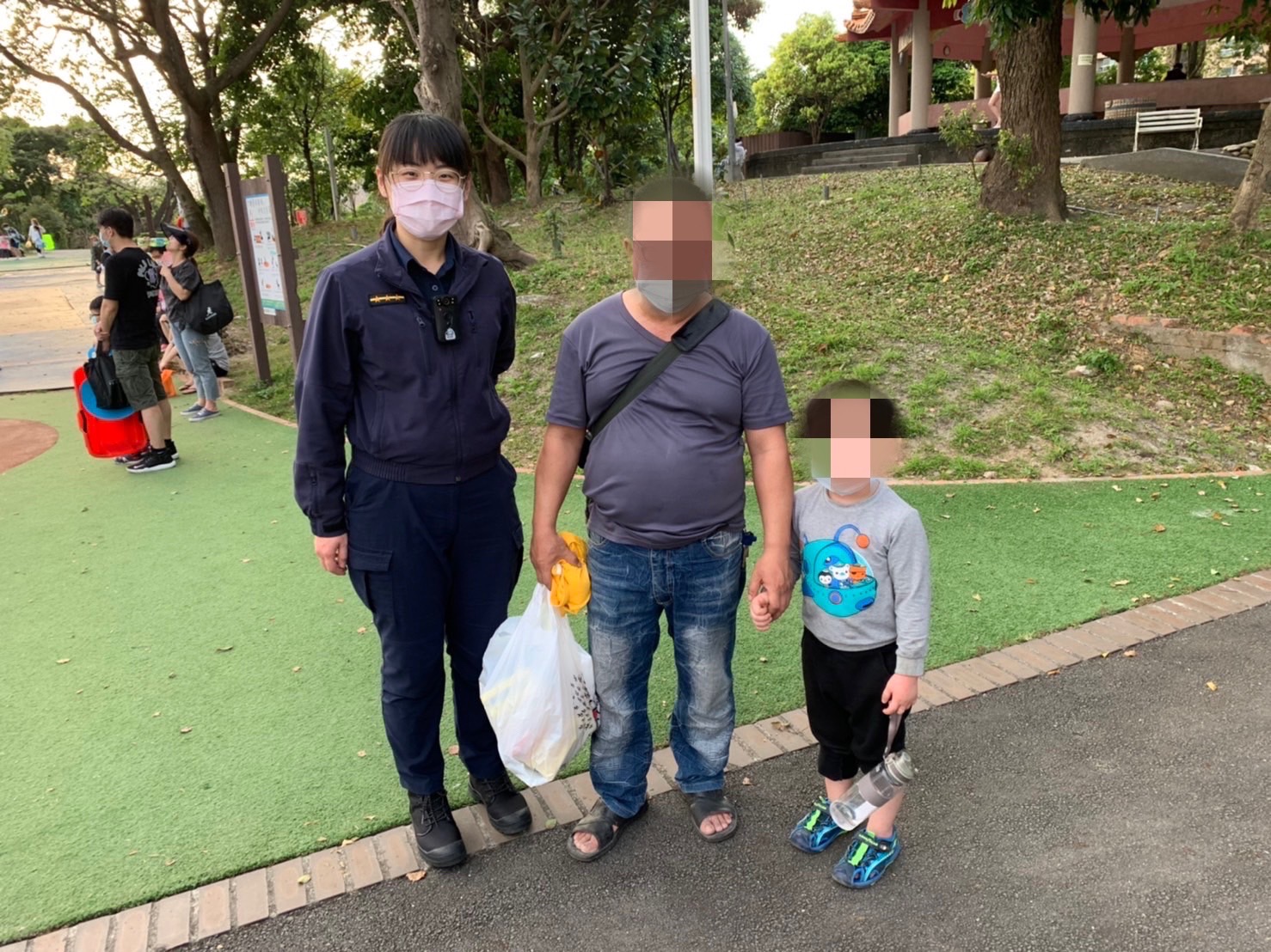 圖片說明：積穗派出所員警陳佩蓉、值班巡佐吳水村助男童找到爸爸。（記者馬治薇翻攝）   