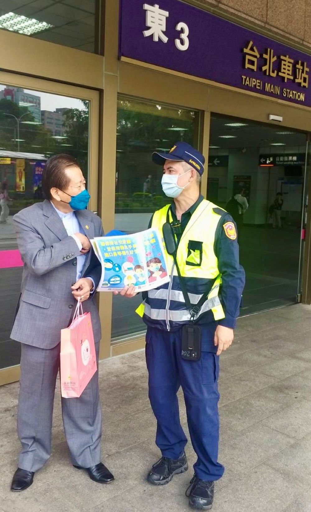 圖片說明：臺北市保安警察大隊手持防疫宣導海報，在臺北車站各出入口處徒步巡邏，執行防疫宣導活動。(記者宋紹誠翻攝）
