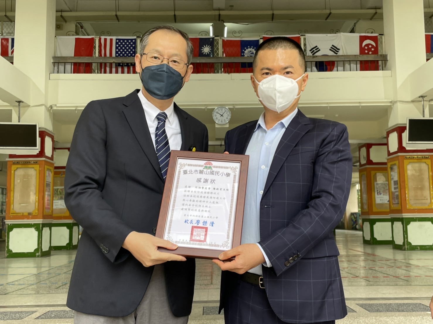 圖片說明：麗山國小校長廖傑隆（左）致感謝狀予宏明建設董事長陳啟宏（右），感謝捐贈防疫物資。(記者葉鈞宇翻攝)