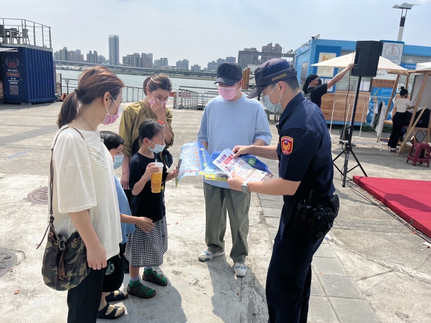 圖片說明：臺北市保大員警特別選在大稻埕碼頭人潮聚集處設置「機動派出所」，以手持海報標語方式向民眾宣導「跟蹤騷擾防制法」。(記者宋紹誠翻攝)