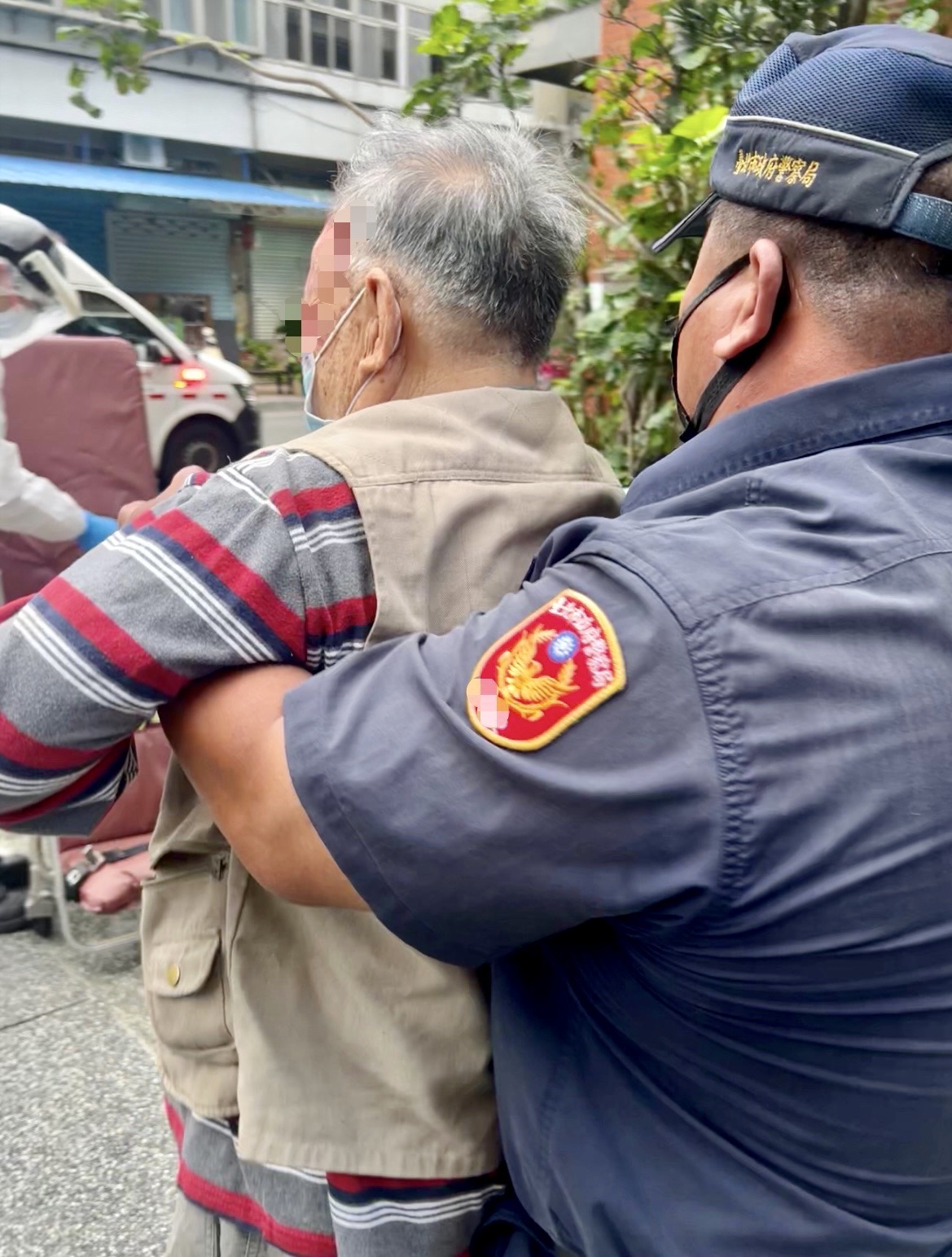 圖片說明：臺北市保安警察大隊警員易法華立刻通報消防局派遣救護車到場救護，並協助攙扶傷者上救護擔架送醫診治。(記者宋紹誠翻攝)