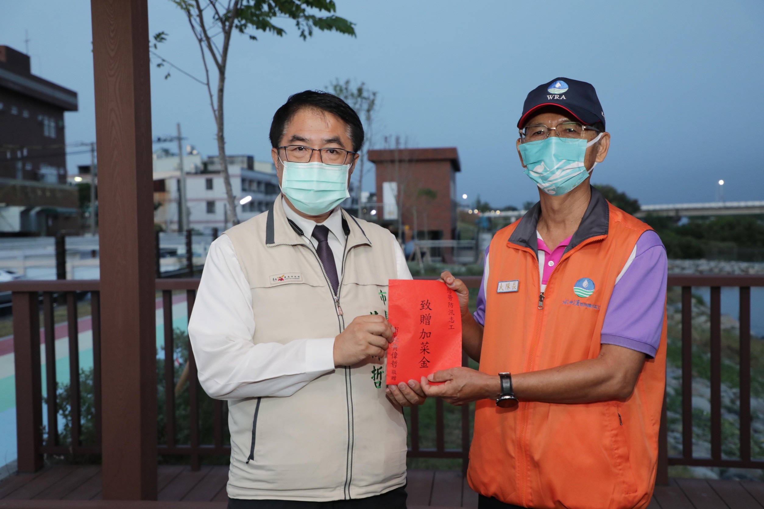 圖片說明：黃偉哲致贈加菜金給防汛護水的志工們，對他們表達敬意與謝意。（記者趙靜姸翻攝）