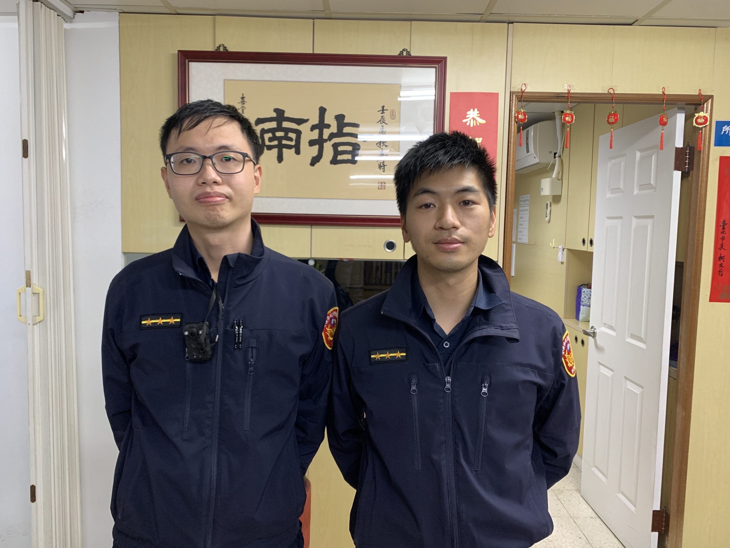 指南所員警莊家承（左）、鄭宇倫（右）巡邏時發現一名精障男裸身遊蕩，立即帶回派出所安置。（記者楊國域翻攝）