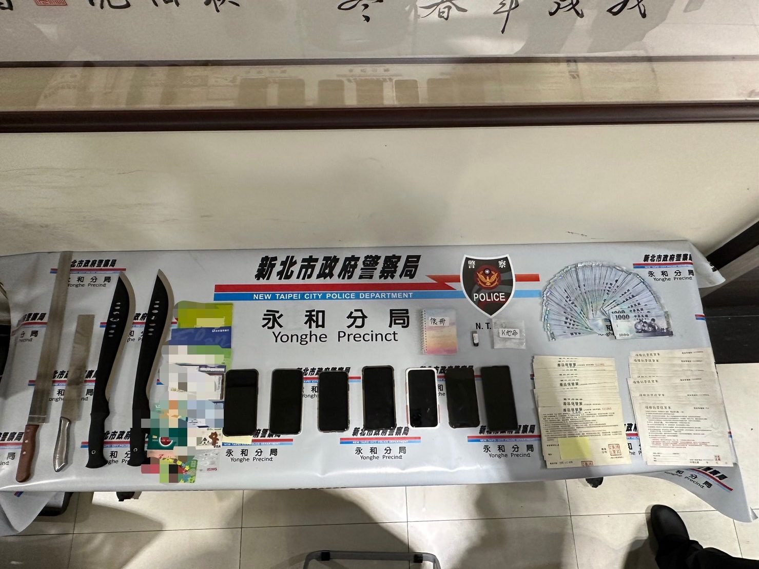 永和警所查獲手機刀械現金等證物。（記者徐煜勝翻攝）