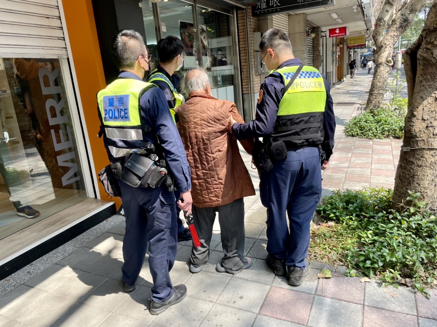 臺北市保安警察大隊員警協助步伐蹣跚受困車陣老翁，順利通過馬路至人行道休息。(記者宋紹誠翻攝)