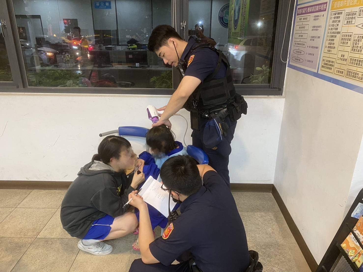 同安所員警黃域揚及黃域晴立即拿吹風機幫田小妹吹乾頭髮。(記者黃荷琇翻攝)