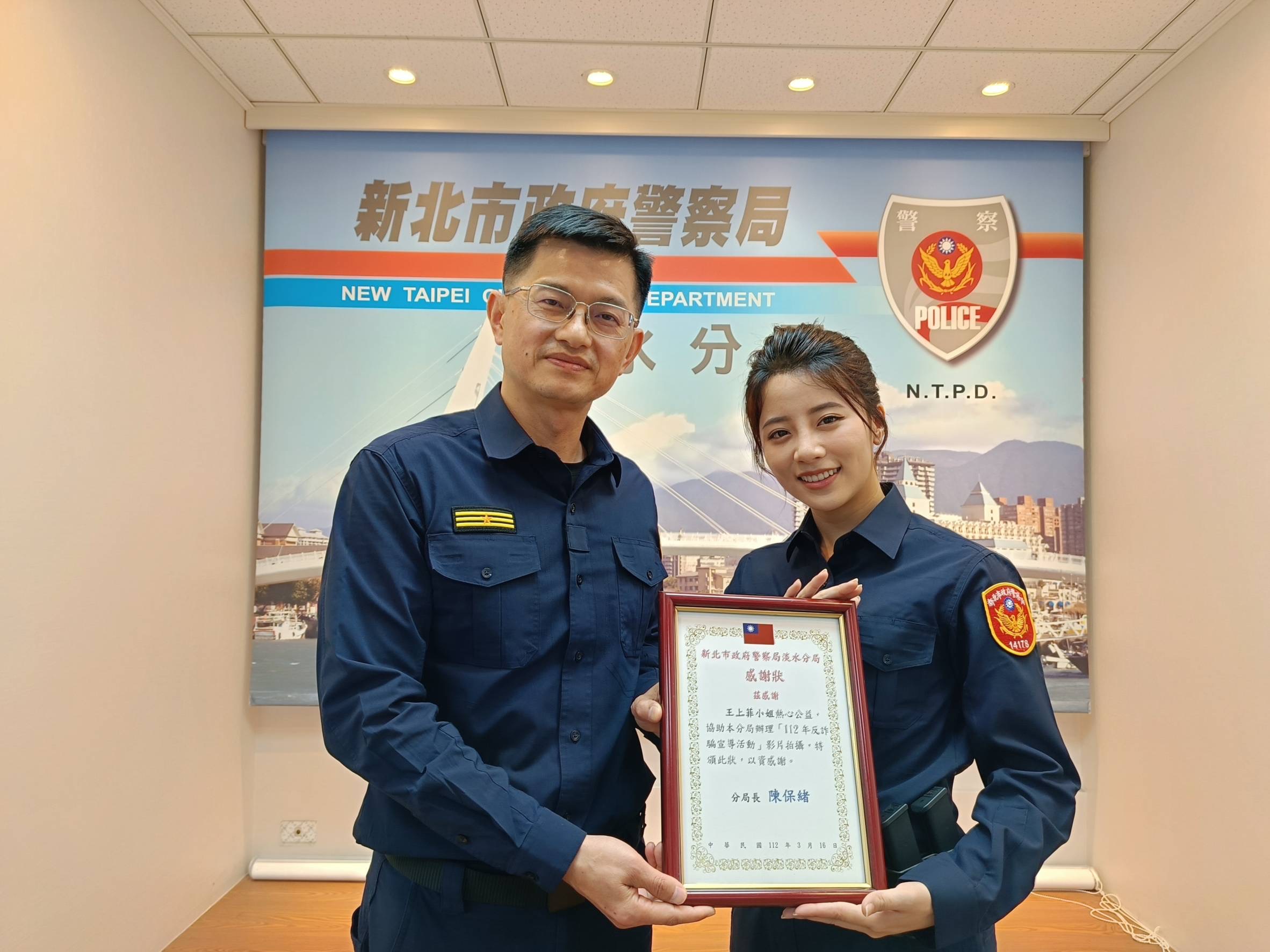 淡水警分局長陳保緒(左)感謝女星王上菲(右)與淡水警ㄧ同拍攝反詐騙短片。(記者戴昱弘翻攝)
