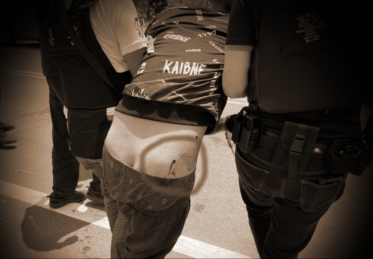 開槍歹徒遭警方開槍擊中臀部,當場倒地,血流如注。(記者徐煜勝翻攝)