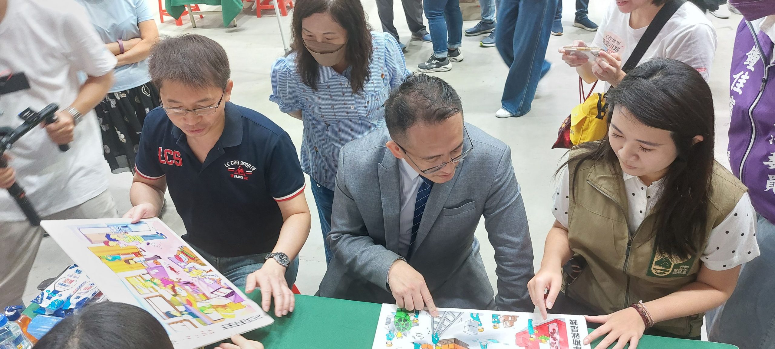 屏東縣黃國榮副縣長(左) 與台積電慈善基金會彭冠宇執行長(中) 屏東縣勞動暨青年事務處李雨蓁處長(右) 在攤位上實際模擬為高中職畢業生設計的就業適性探討活動(照片提供/台積電慈善基金會)