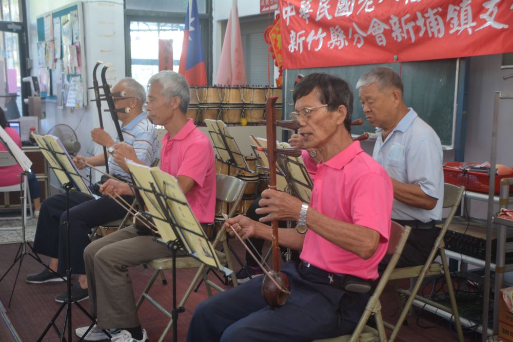 新埔老人會舉行二胡研習班成果發表會,學員在舞台上展現三個月的學習成果。〈新埔鎮老人福利協進會提供〉