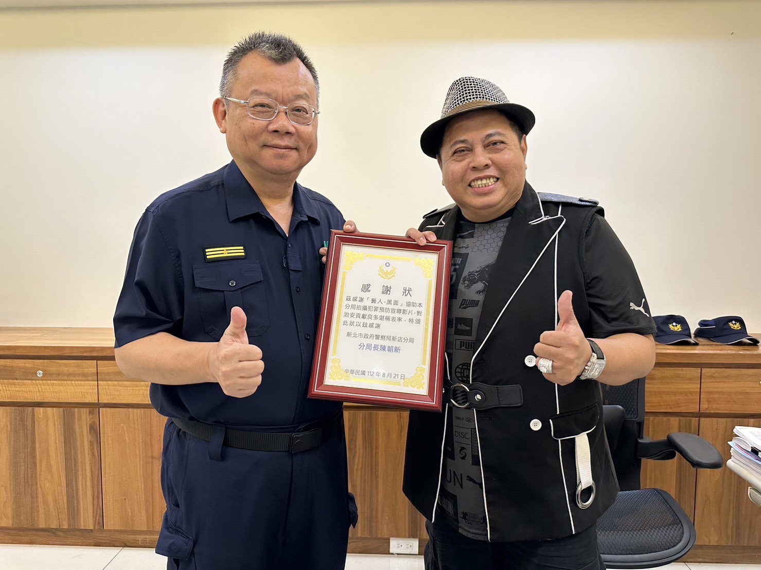 為感謝「黑面」林郁順(右)反詐騙宣導的貢獻,新店分局長陳朝新(左)為頒感謝狀。(記者戴昱弘翻攝)
