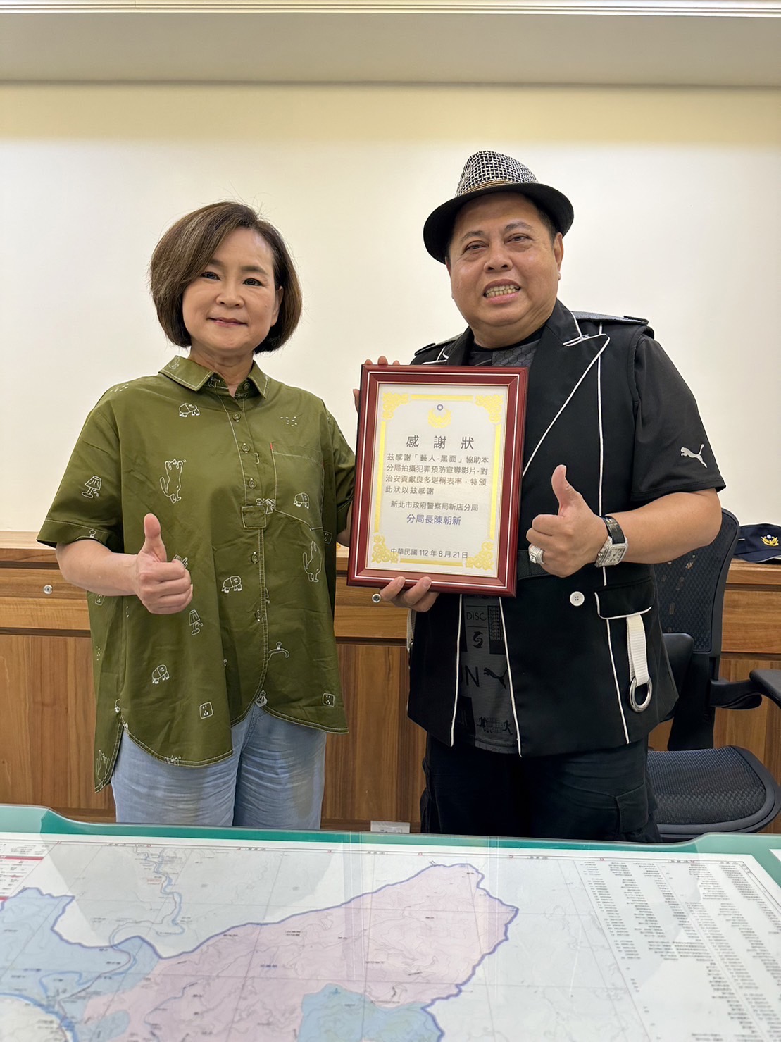 新店分局義刑中隊長吳春美(左)與「黑面」林郁順(右)合影。(記者戴昱弘翻攝)