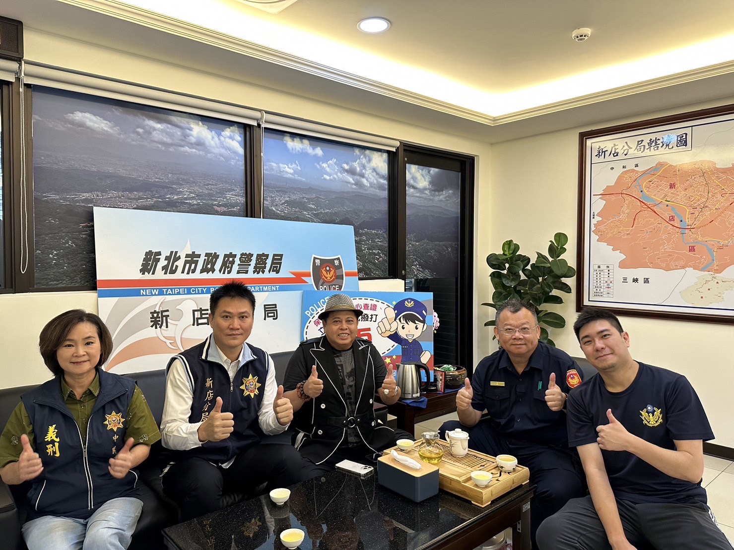 本土藝人「黑面」林郁順(中)在新店分局與分局長陳朝新(右2)等人合體共同反詐騙宣導。(記者戴昱弘翻攝)