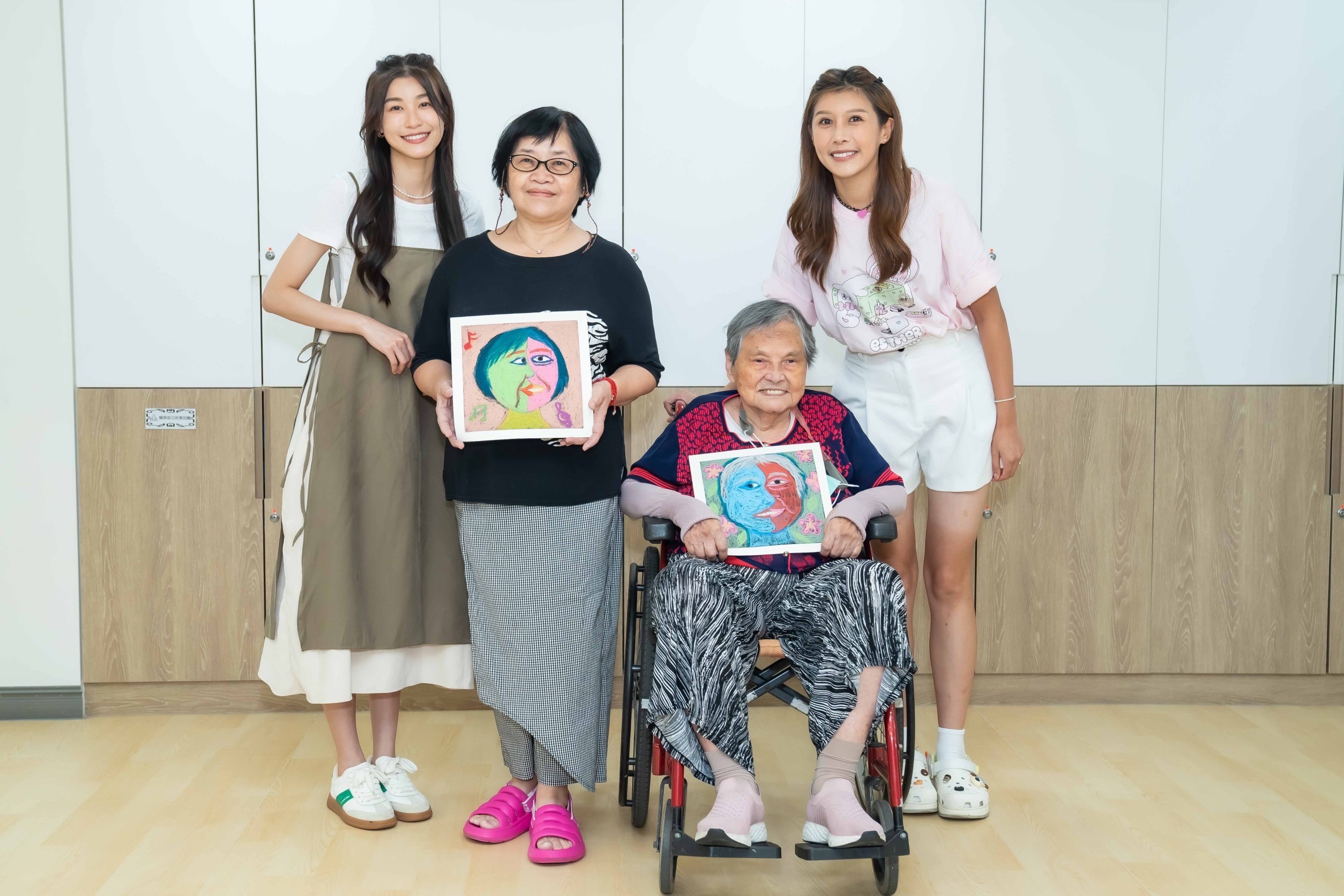 「孫睿」與 「陳俋塵」一起陪伴中心的爺爺奶奶們,透過藝術彩繪的方式,畫出幸福的臉譜。(照片/紅心字會提供)