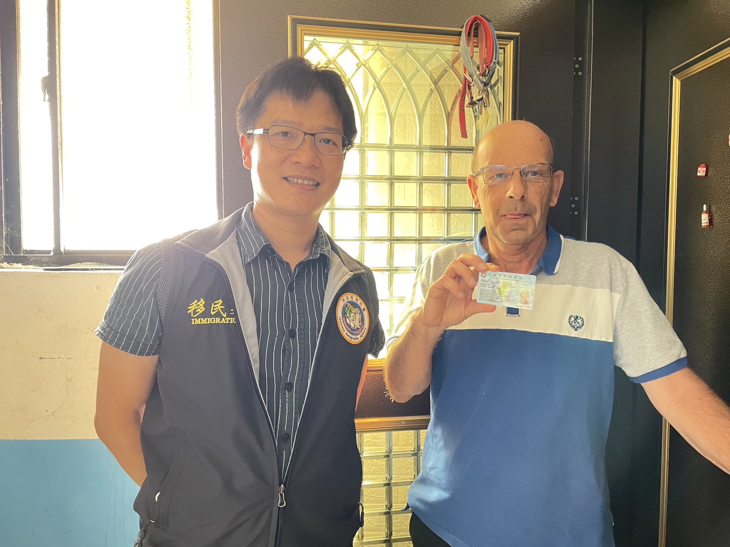 楊麥克對造訪的移民署官員說，很開心取得中華民˙國居留證。(記者張欽翻攝)