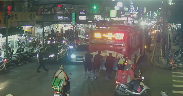 南勢角捷運站路口207公車拋錨,景安所5員警齊力推車,協助交通疏導。(記者張艷君翻攝)