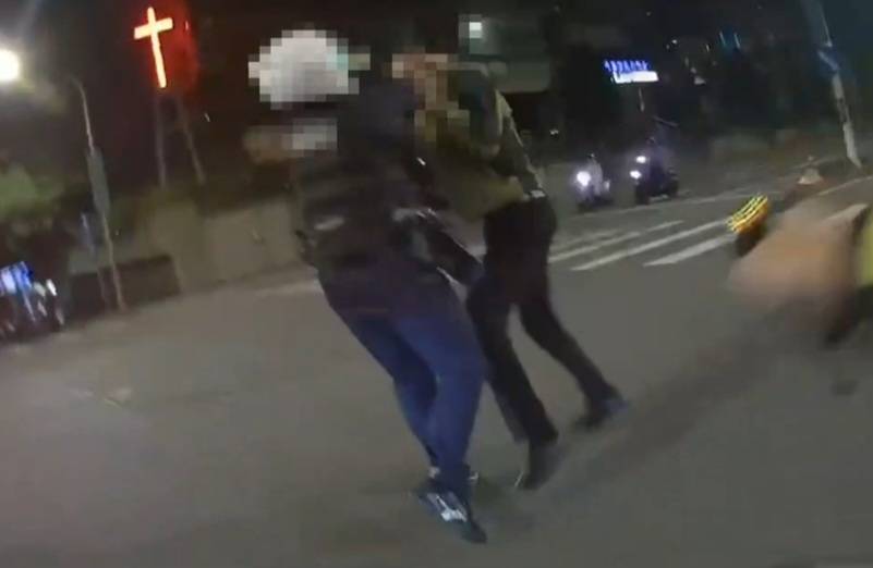 男子持釘耙攻擊警員。(記者林金聖翻攝)