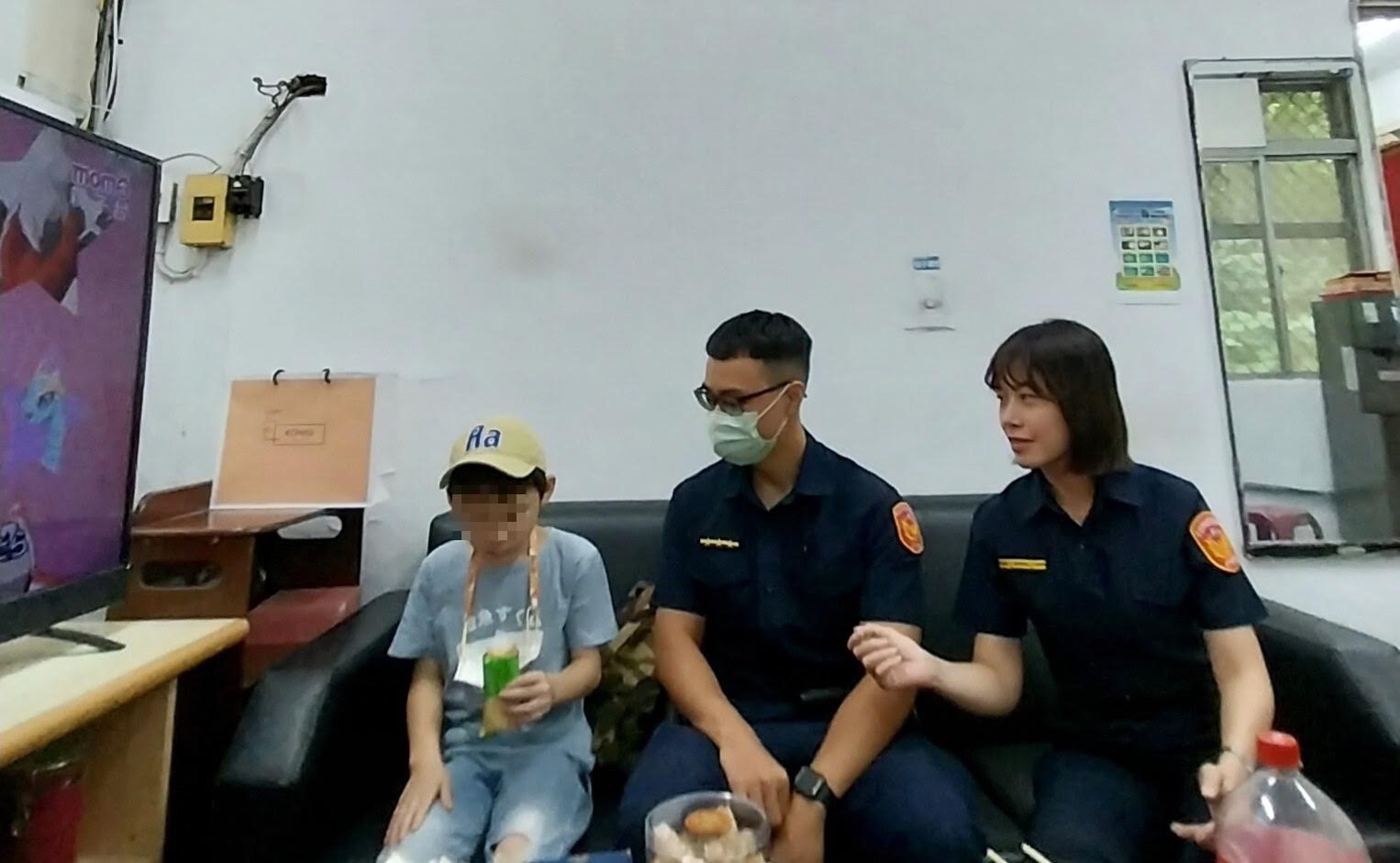 男童走失被熱心民眾帶到北投分局關渡派出所,所長陳以雯及警員郭駿宏一邊悉心照料男童,一邊連絡家長。(記者薛秀蓮翻攝)