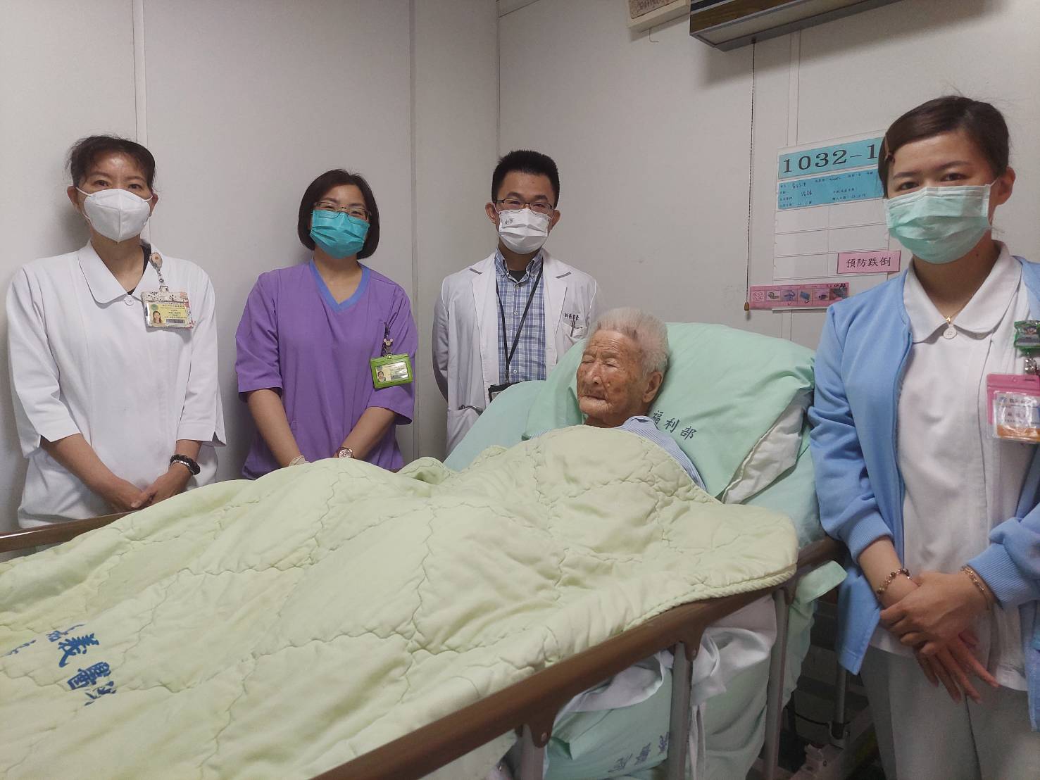 部嘉醫院張書豪醫師腹腔鏡手術成功救治近百歲人瑞並與醫療團對照護時合影。(部嘉醫院提供)