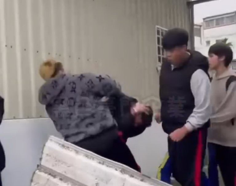 影片中至少有3人動手毆打抱頭的原住民學生。(圖/翻攝自黑色豪門)