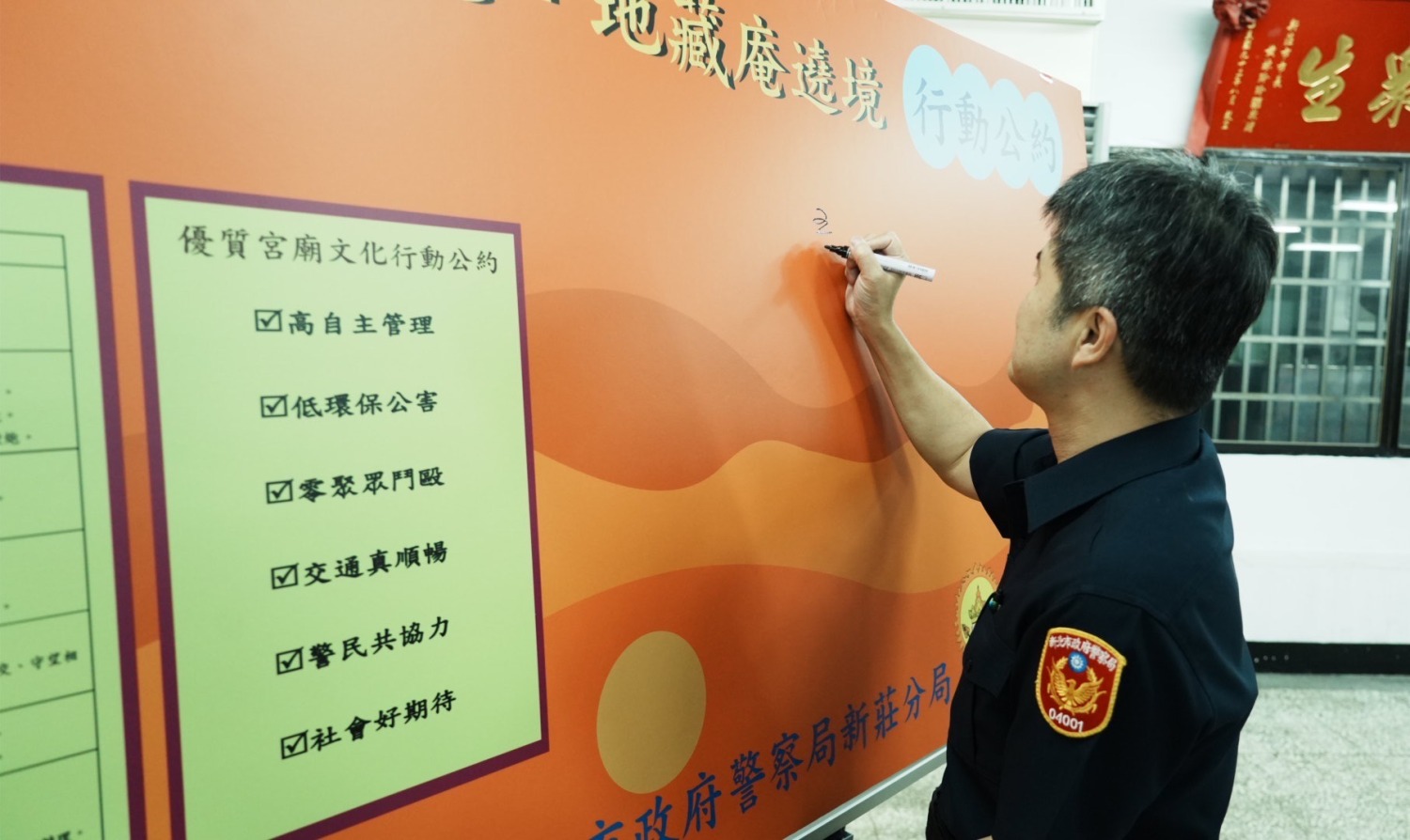 新莊分局長王鴻儒帶頭於公約上簽字。(記者徐煜勝翻攝)