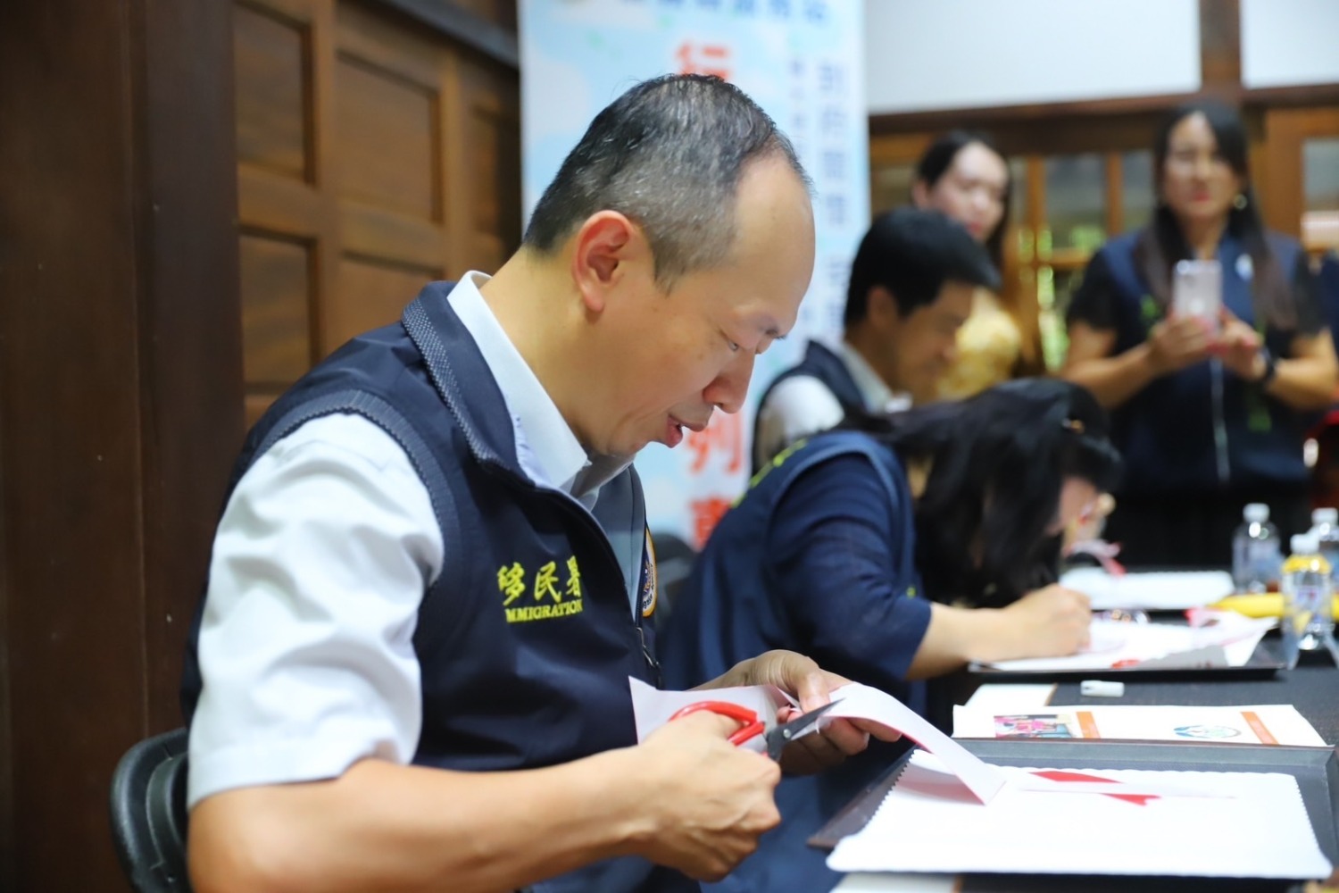 移民署謝文忠主任秘書訪視嘉義縣青翼文化產業協會,體驗剪紙藝術。(記者 張艷君翻攝)