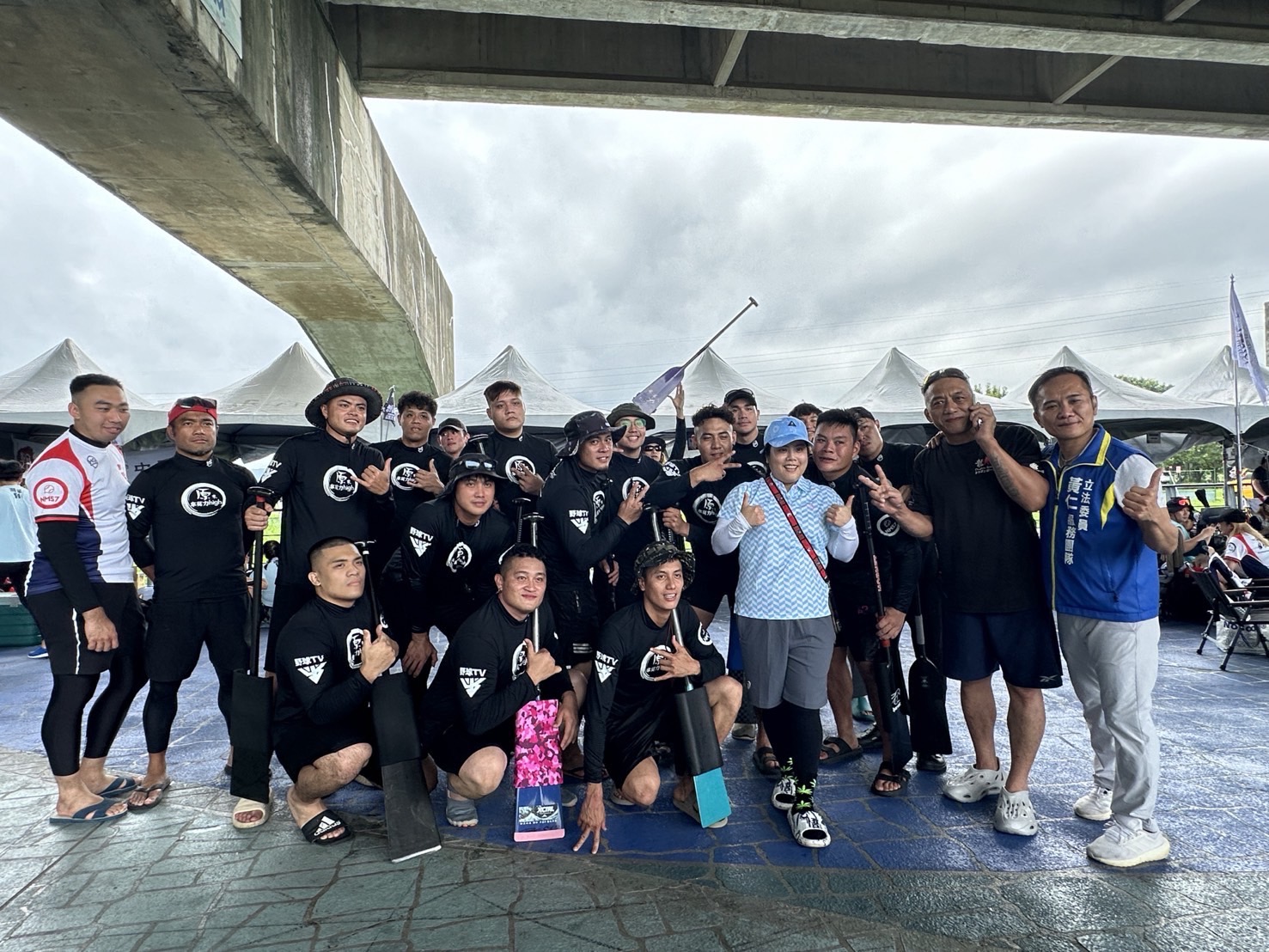 關心每年端午節舉辦的體育競技----新北市議長盃龍舟錦標賽,平地原住民立委黃仁特別指派特助陳偉華陪同新北市平地原住民議員宋雨蓁(右4,戴淡藍色球帽)一同為參賽隊伍加油打氣。(記者包克明 翻攝)