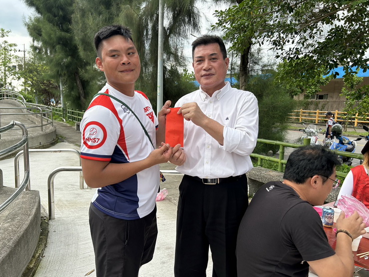 黃仁致贈加菜金嘉勉奪冠的龍舟隊。(記者 包克明攝)