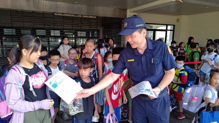 分局長童寶賢於七堵國小與學童互動鼓勵發放宣導品。(記者薛秀蓮翻攝)