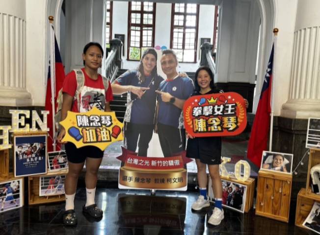 陳念慈的人形立牌在市府大廳,供民眾老少熱情拍照打卡,隔海叫陣加油!(圖/記者黃溎芬翻攝)