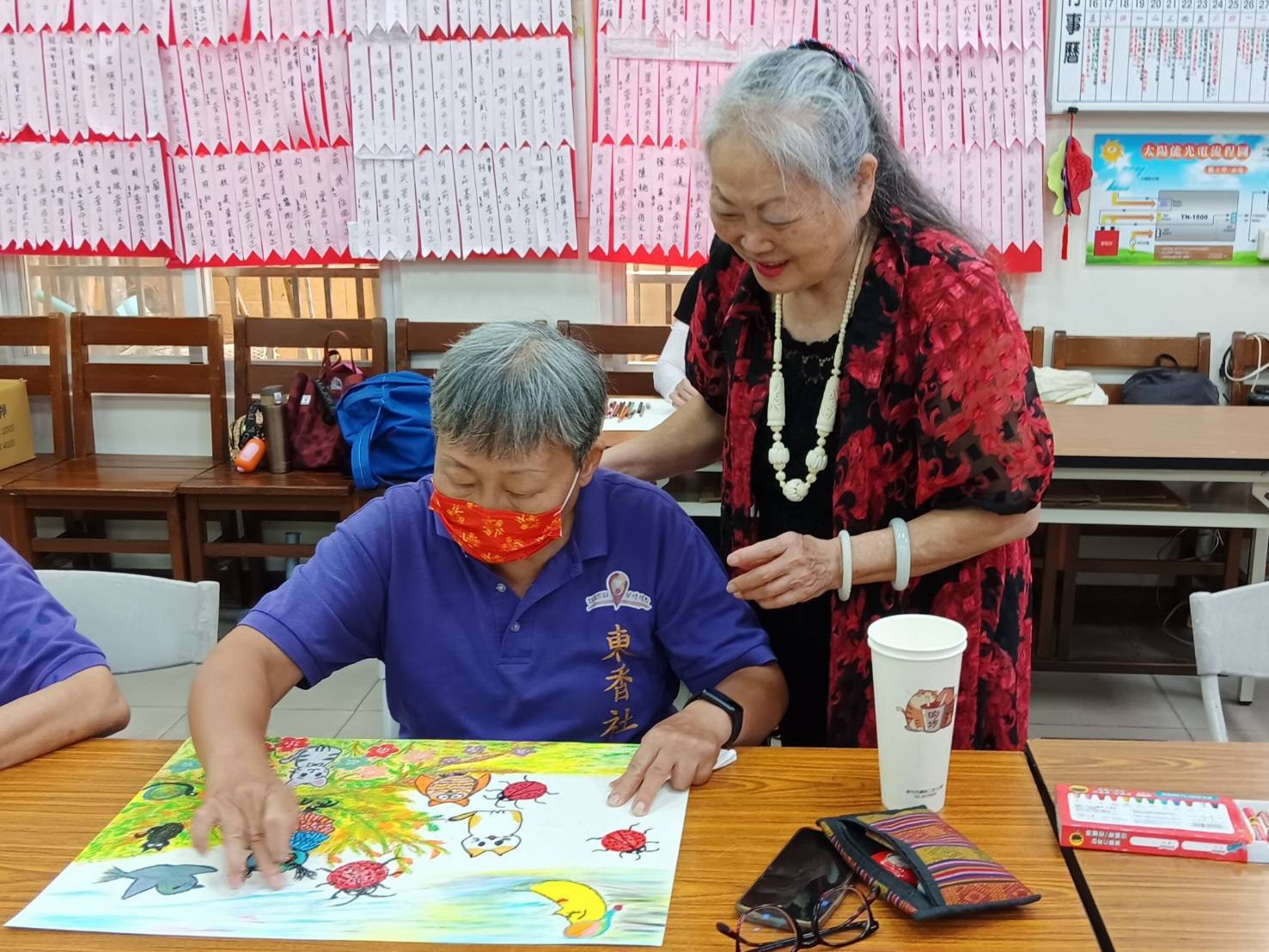 朱麗麗悉心引導長輩發揮繪畫創作潛能。(圖/記者黃溎芬翻攝)