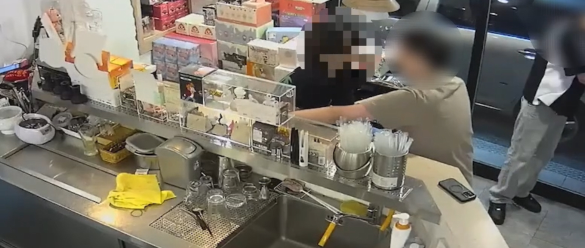 陳嫌(左黑衣者)行竊不成遭拆穿欲離開被陳姓飲料店長(右綠衣者)制止。(記者徐煜勝翻攝)