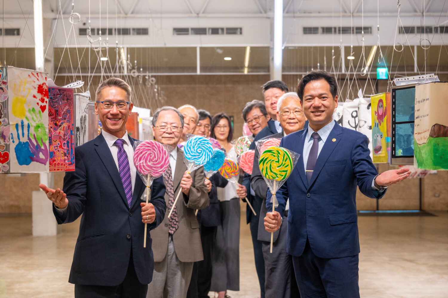清華校長高為元(左一)與新竹市代理市長邱臣遠(右一)手持特製棒棒糖,與貴賓們共同為「2025年春之清華藝術節」揭開序幕。(圖/記者黃溎芬翻攝)