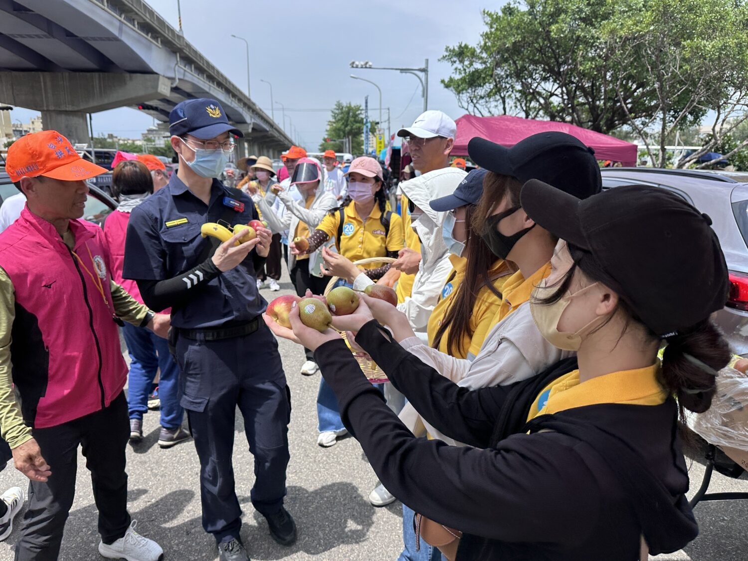 現場志工熱情的為執勤警官加油打氣,並遞上滿滿的愛心水果。(圖/記者林照東攝)