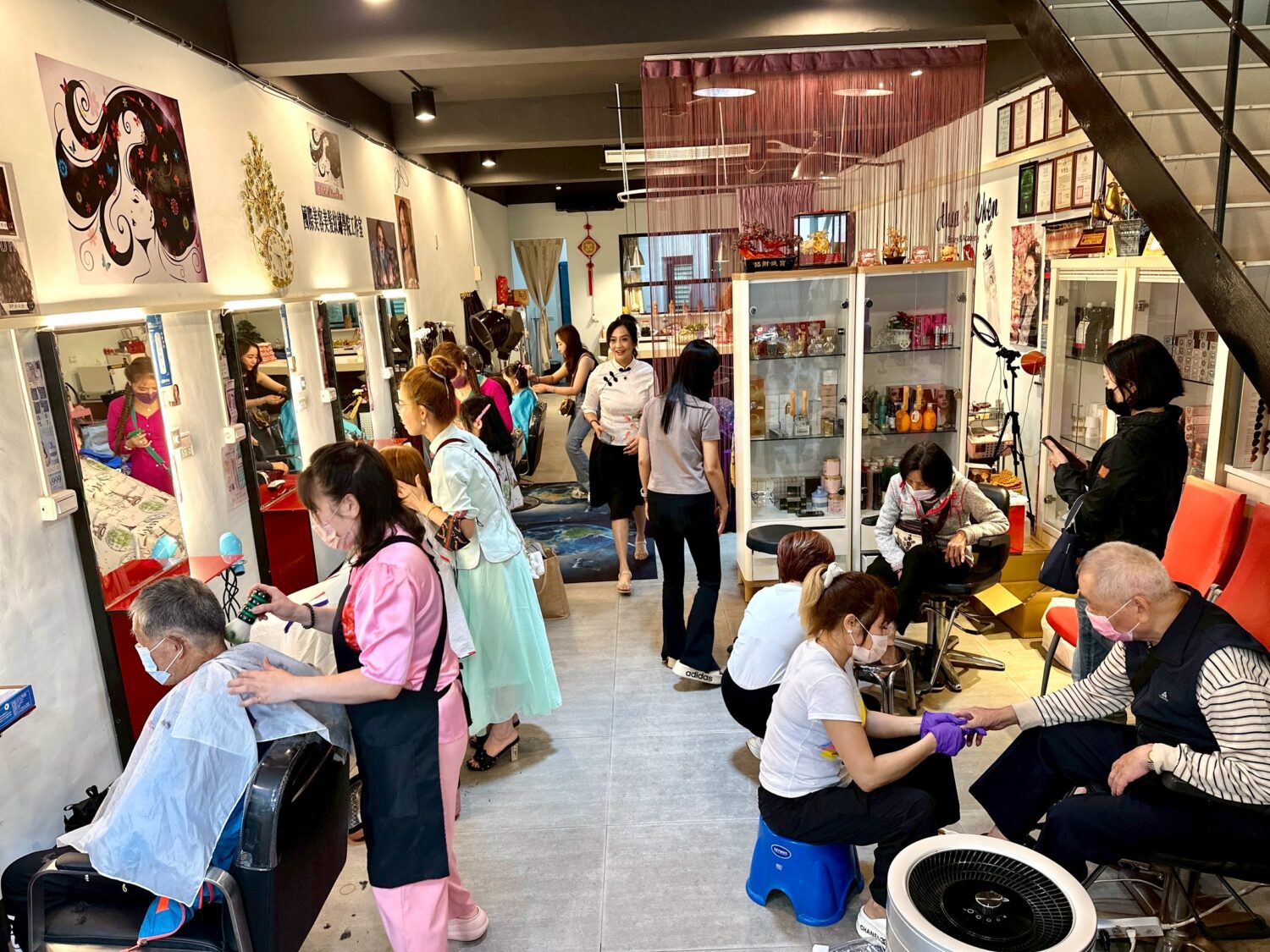 陳黃如老師一早就準備好康乃馨及養生涼麵,為社區民眾提供義剪服務。(圖/記者林照東攝)