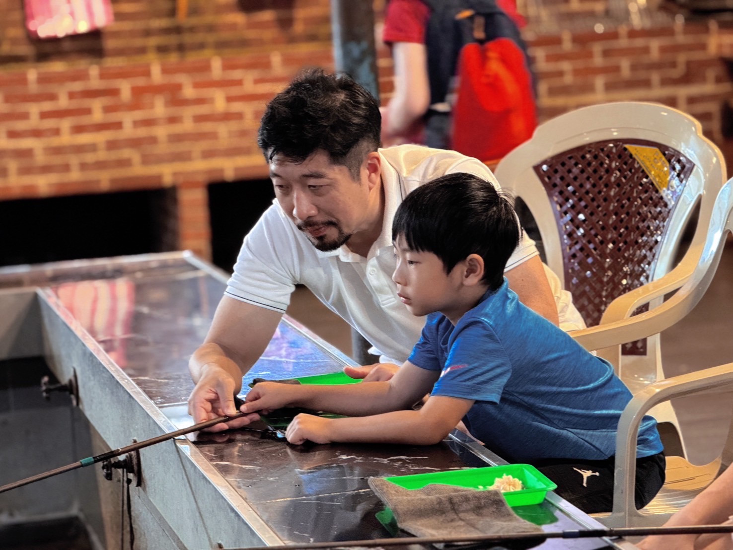 與孩子專注體驗釣蝦樂趣，展現溫馨親子時光。（圖/記者林照東翻攝）