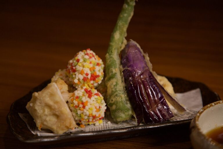 芥末蓮藕天婦羅盛合｜源自熊本當地家庭料理的經典做法，蓮藕餅是將蓮藕切片中夾入花枝漿，以及芥末蓮藕，將蓮藕捏碎加入芥末塑形而成，再裹粉酥炸。酥脆外層搭配鹹香內餡，清爽中帶點刺激，是居酒屋人氣定番菜色。(圖/ABV南洋餐酒館提供)