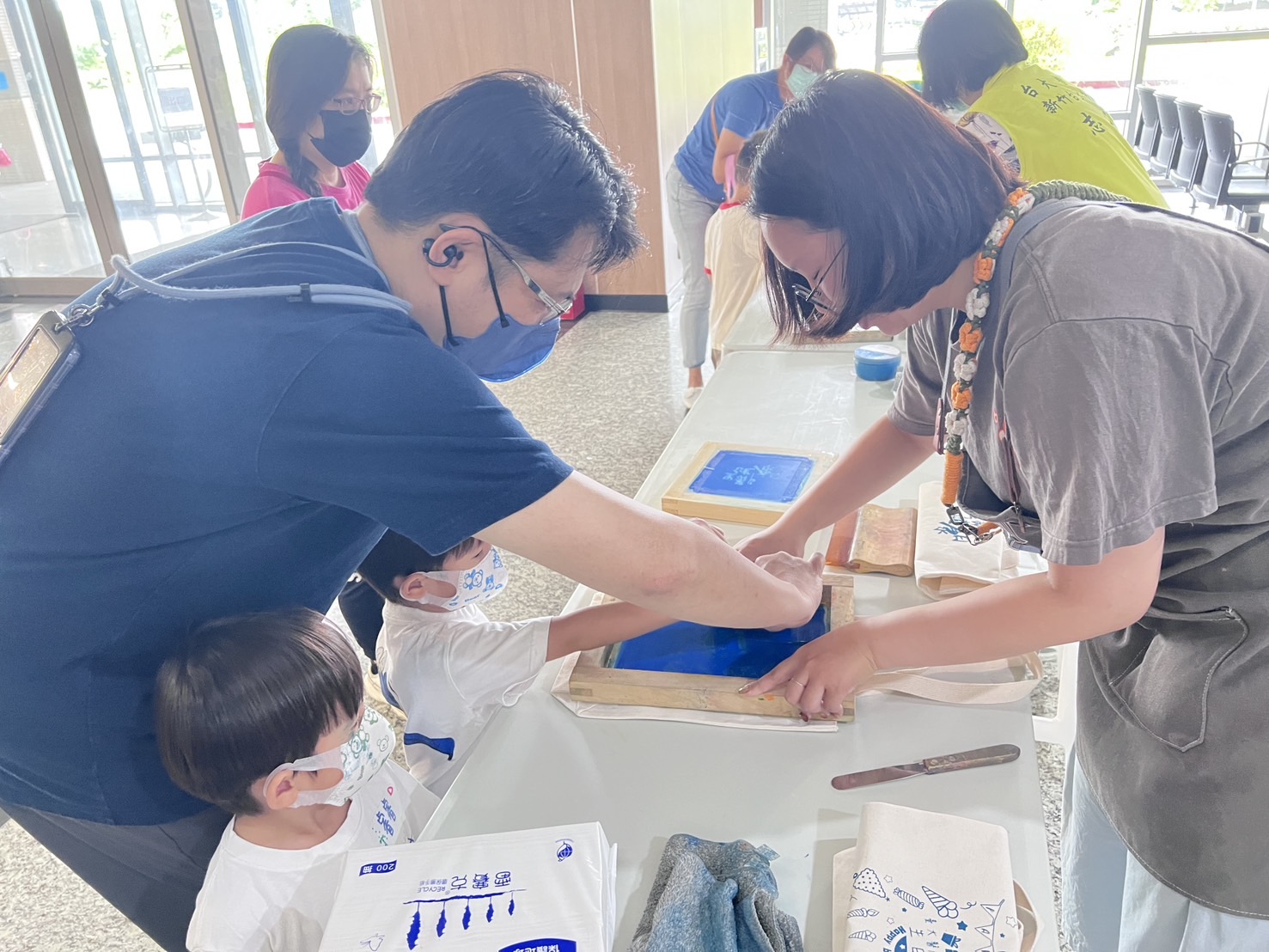 民眾與孩子們在志工協助下體驗絹印DIY，透過親手創作，將永續理念與健康生活落實於日常，活動氣氛熱絡，大小朋友都樂在其中。（圖/記者張家燁翻攝）