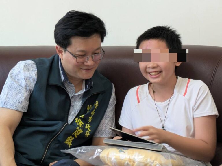 小如開心的拿自己手繪的漫畫跟徐健麟分享。