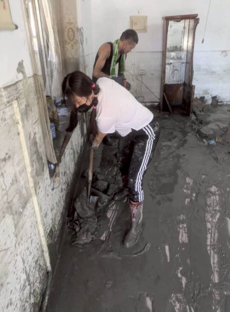 中醫大新竹附醫護理師王儀臻（白色上衣）加入志工行列，在滿屋泥濘中奮力清理家園，展現最堅定的行動力與人情溫度。（圖/記者張家燁翻攝）