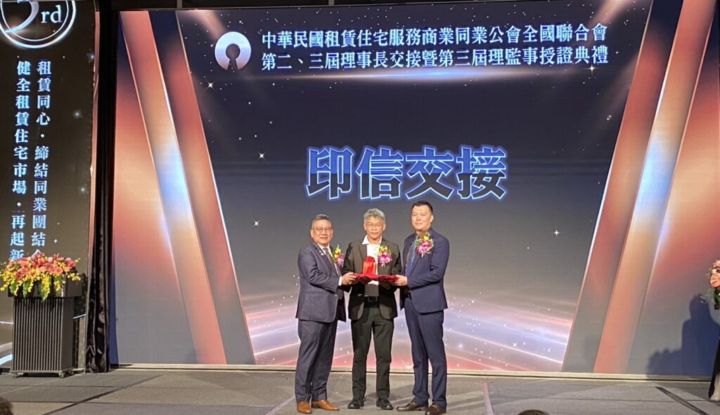 新任理事長劉貞君(右)從中華民國租賃住宅服務商業同業公會全國聯合會第二屆理事長鄭俊杰(左)手中接過印信。(記者 包克明攝)