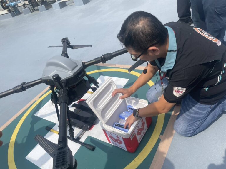 新竹捐血中心工作人員將血液放入專業運輸容器，搭載於無人機進行緊急送血展演，確保血液品質安全穩定。（圖/記者張家燁翻攝）