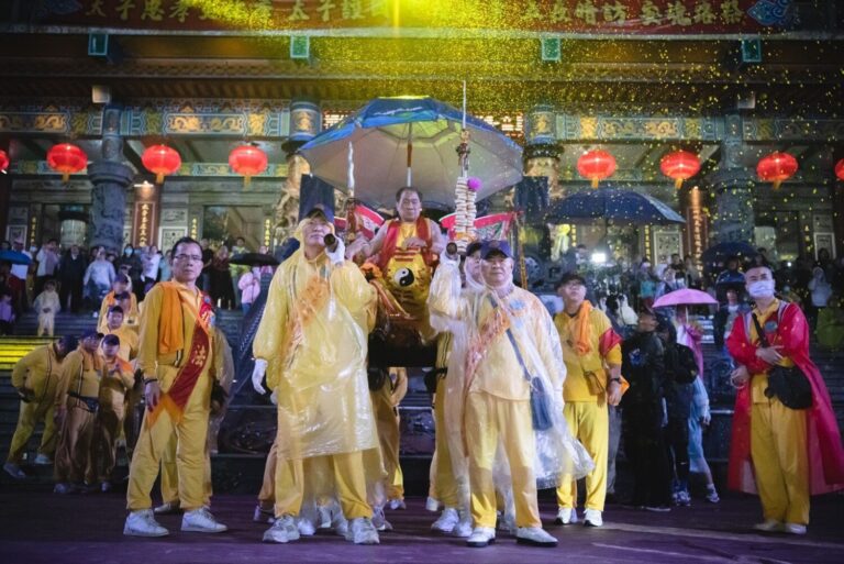 桃園護國宮太子爺「五夜暗訪」風雨中回鑾，太子爺在閱兵台上陣頭一一參禮，頭家們和貴賓扛著釘椅恭迎聖駕。（圖／桃園護國宮提供）