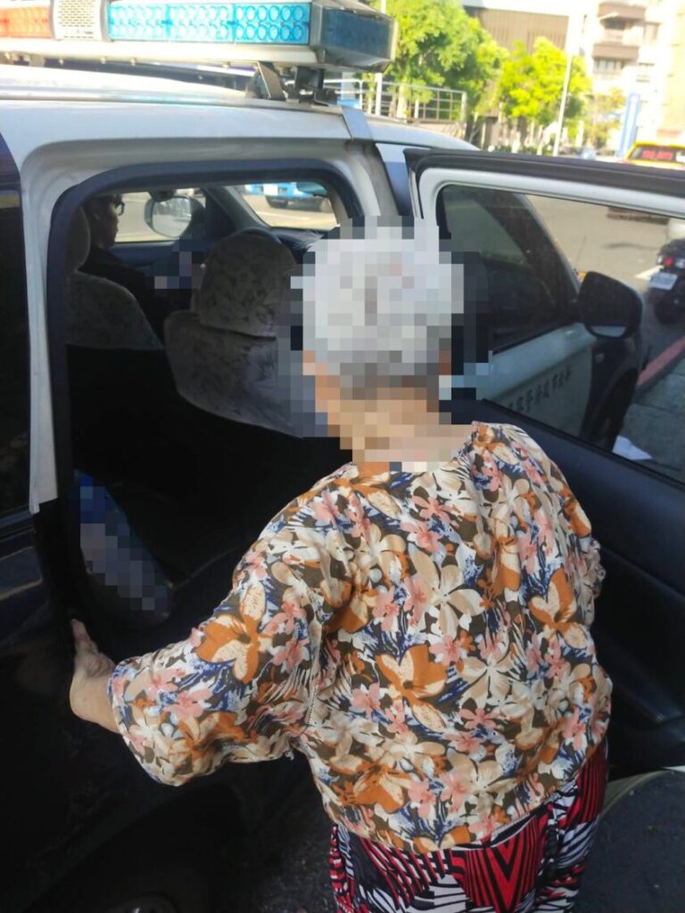 員警護送民眾上警車返家。(記者李健興翻攝)