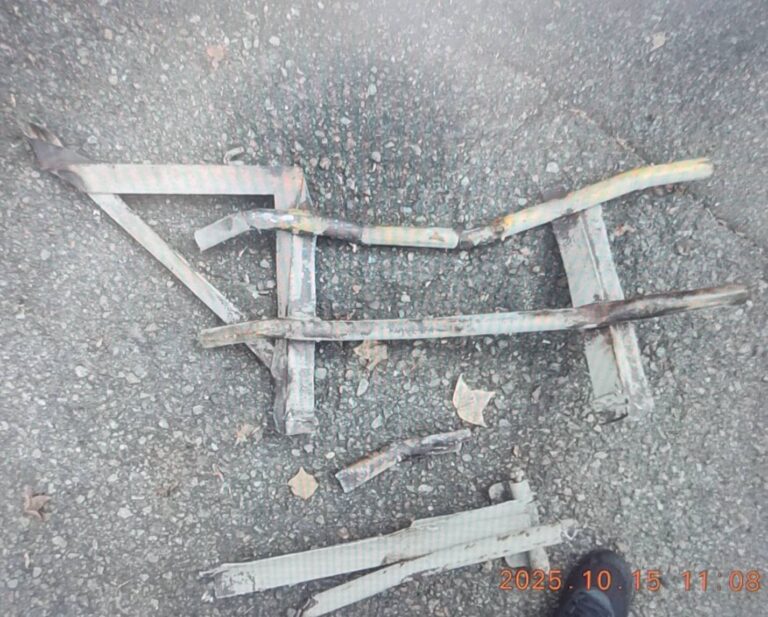 掉落在道路上的防捲入裝置欄杆，因鬆脫飛出導致自小客車受損。（圖／記者林家嘉翻攝）